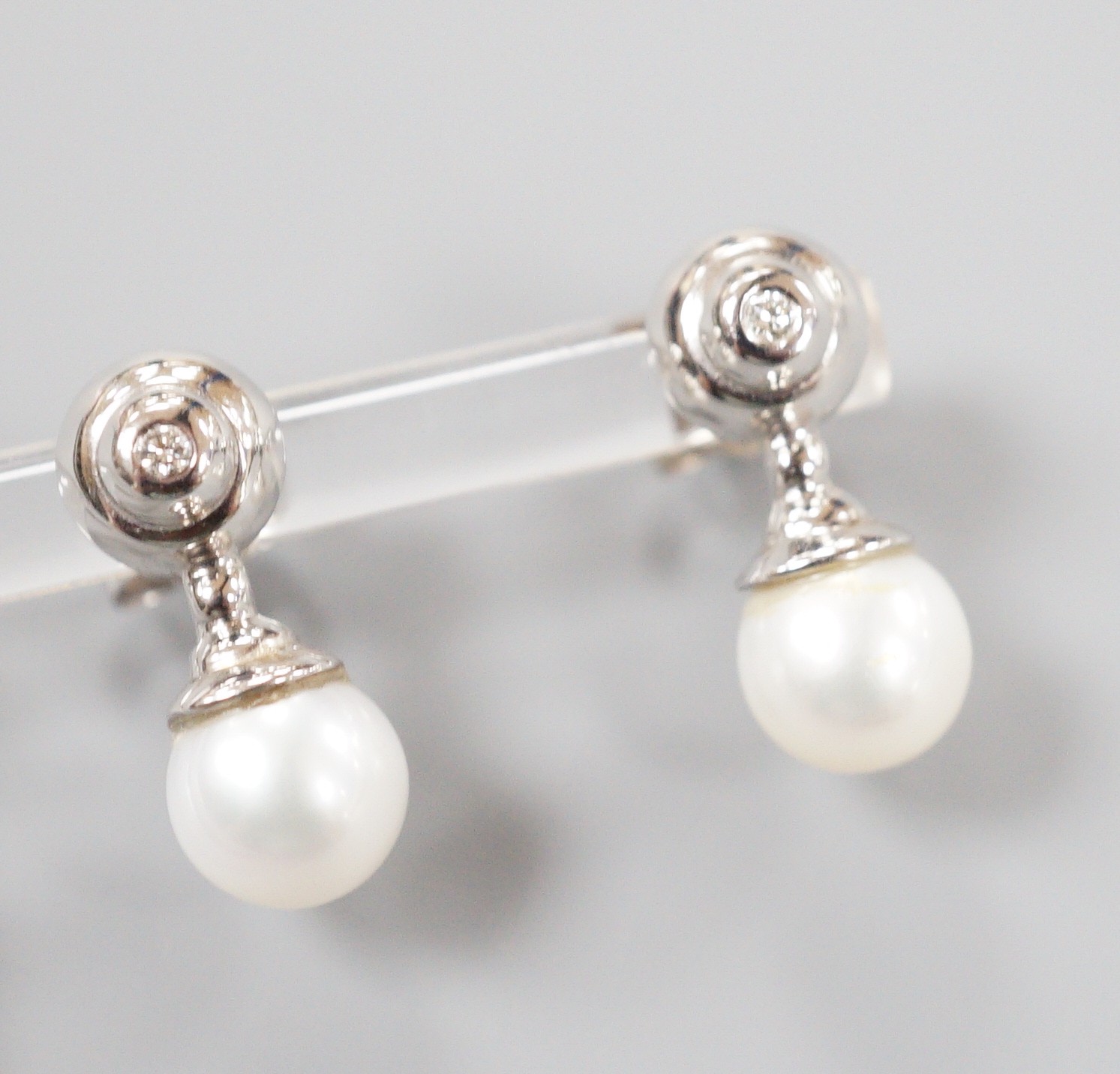 A modern pair of 198ct white gold cultured pearl and single stone collet set diamond ear studs, 19mm, gross weight 5.4 grams.